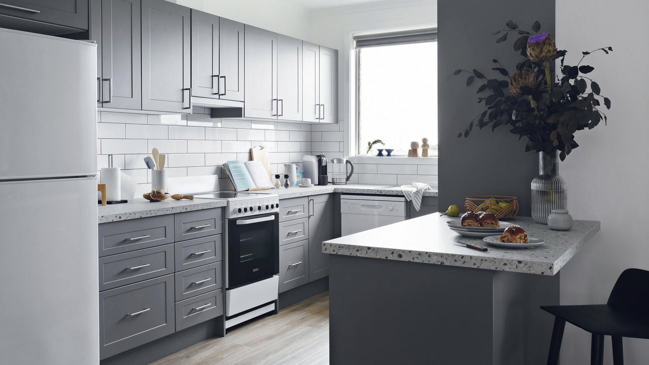 Kitchen with grey cabinets and a white tile splashback.