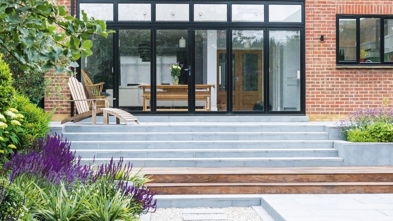 Exterior of a brick house with a recliner and pavers.