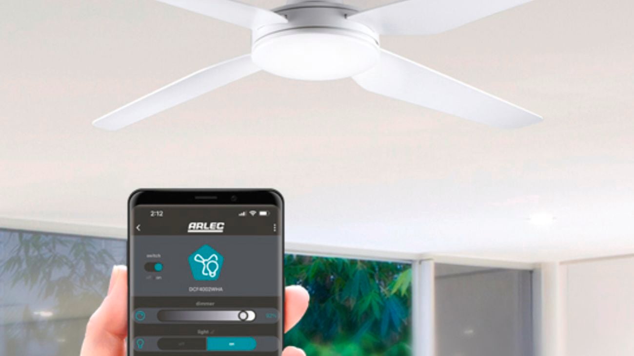 Hand holding a smartphone with the screen displaying the Grid Connect app from Arlec. Using the app to control the ceiling fan in the background.