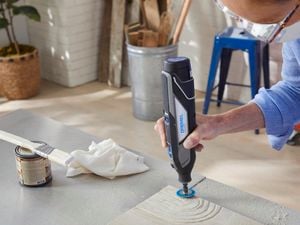 Person using Dremel sanding tool to create shapes in sandstone