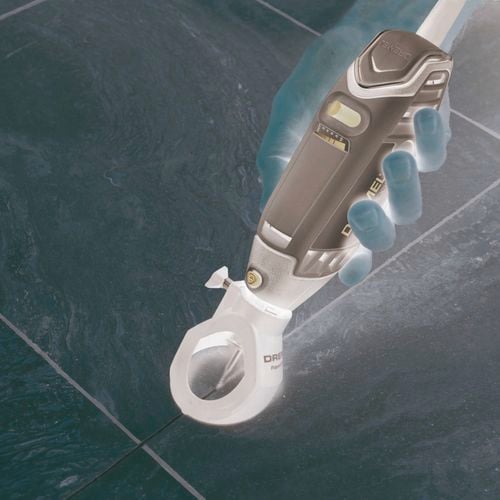 Dremel tool removing grout between floor tiles.