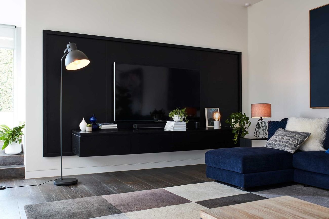 Living room with large television mounted to wall and blue couch