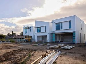 A half complete building on a clean jobsite with mud in the foreground.