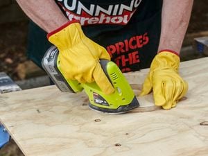 Sanding a piece of wood with a cordless sander.