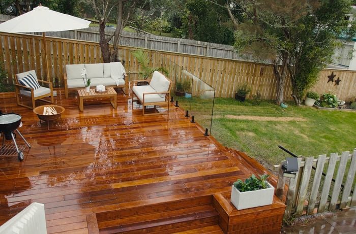 Back garden with timber decking showcasing glass fencing and lounge