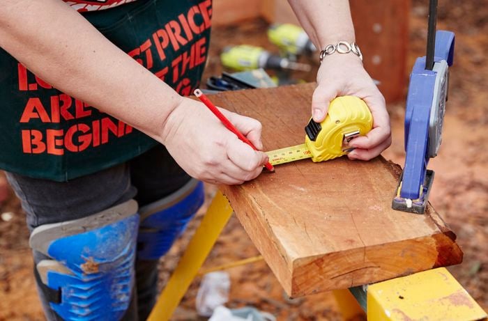Inner gate guides measured and marked for cutting with a tape measure and pencil, with a clamp holding it down
