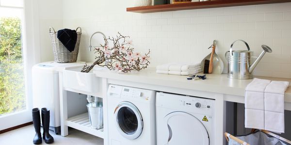 Laundry with washing machine, dryer, watering can and gumboots