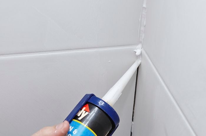 Sealant being used to fill gaps in a bathroom