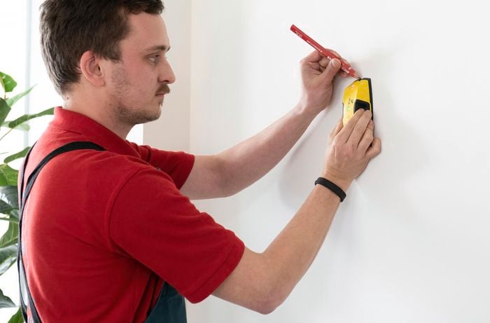 A Bunnings team member finding the stud beam in a wall