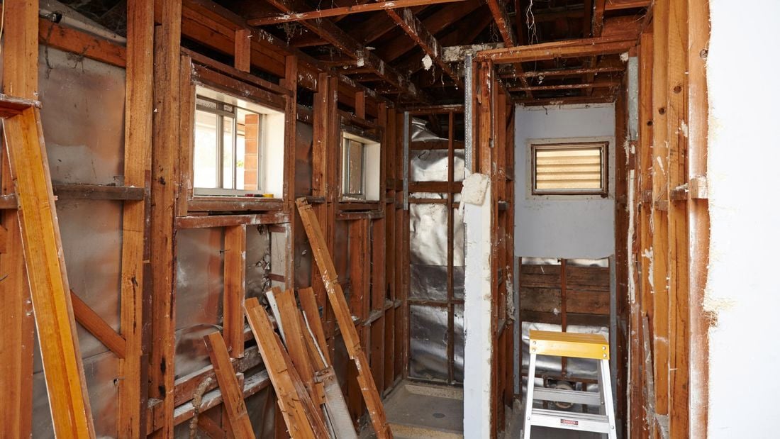 A room of exposed wall frames, with a standing ladder to one side