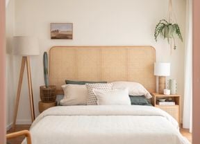 In a neatly decorated room, there are five basketballs hanging on the wall. A guitar is placed in the corner, alongside a study desk and chair. Additionally, there is a small bed with a brown beanbag