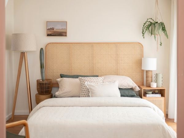 In a neatly decorated room, there are five basketballs hanging on the wall. A guitar is placed in the corner, alongside a study desk and chair. Additionally, there is a small bed with a brown beanbag