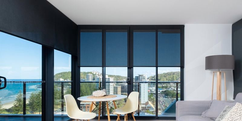 black roller blind in high level apartment with a dining table and couch