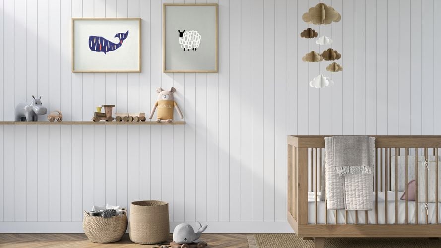 Baby room with timber crib, shelf with toys, prints on walls and timber flooring in neutral tones. Classic VJ 100 design in Dulux Warm White.