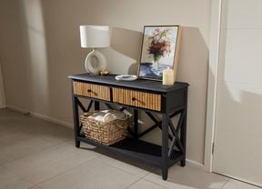 Black hallway console, with timber slat drawers and styled with a wall print, lamp and candle.