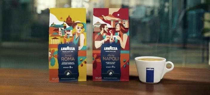 Lavazza Roma and Napoli coffee packs displayed on a table beside a Lavazza espresso cup in a modern indoor setting.