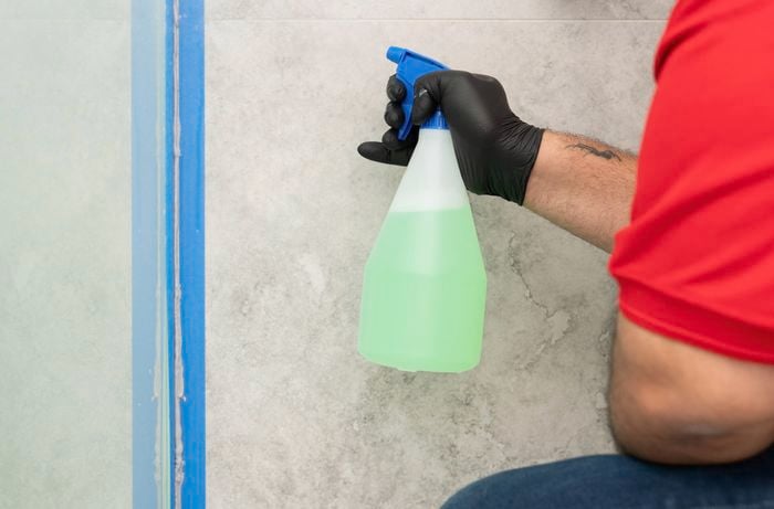 A light mist of soapy water is applied to fresh silicone to help achieve a smooth, professional finish.