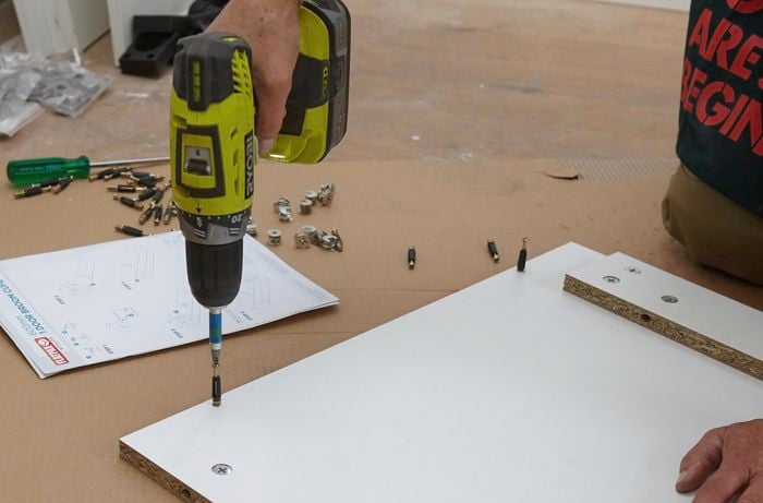 Person drilling into a panel.