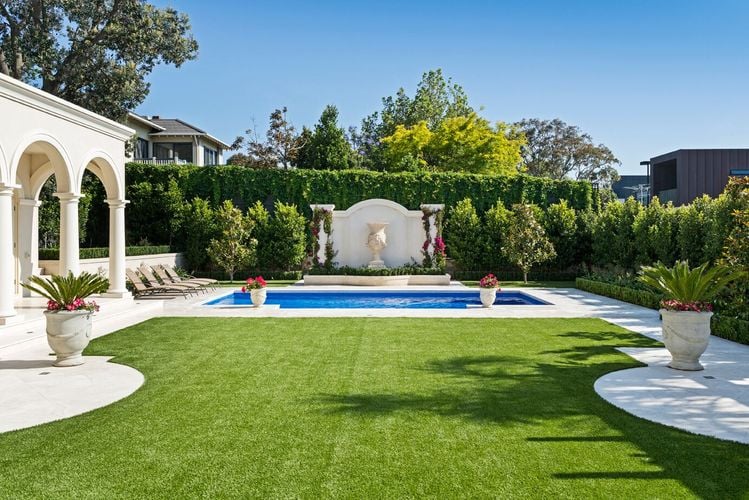 A lawn overlooking a pool as part of a classically themed outdoor setting