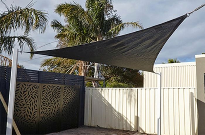 A shade cloth raised over a backyard