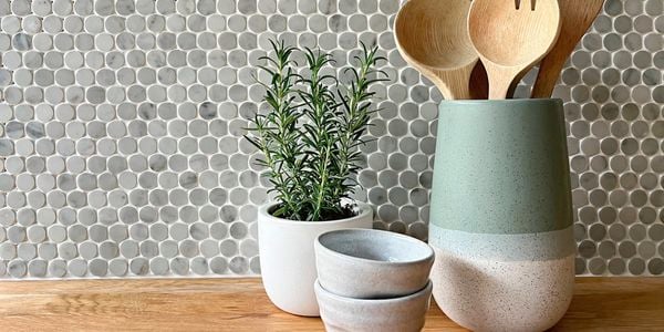 Decor on table in front of mosaic tile splashback.