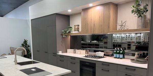 Dark grey kitchen with white and grey benchtops.