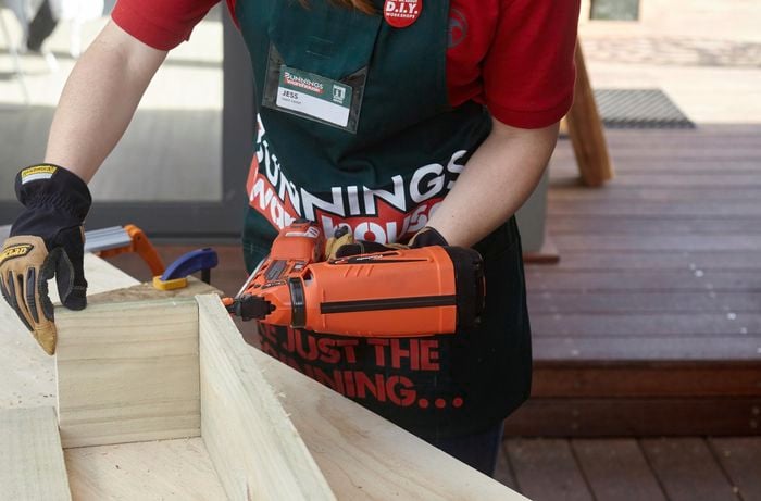 Bunnings team member Jess joining lengths of timber with a nail gun