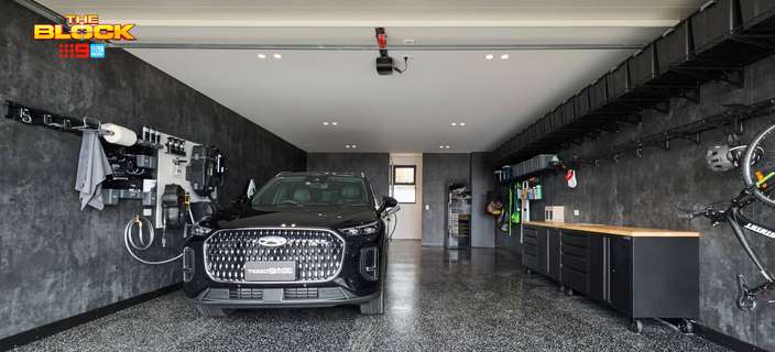 Modern garage featuring a black SUV, polished speckled flooring, wall-mounted storage, bicycles and built-in cabinetry.