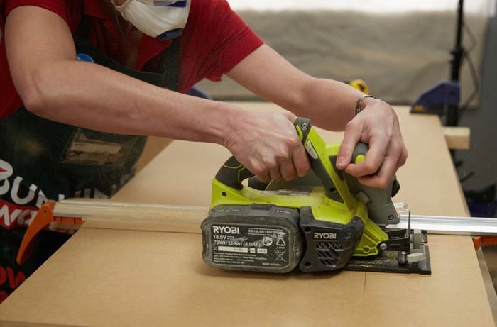Person cutting timber with circular saw