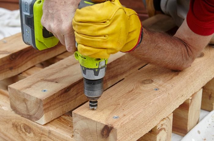 Framework for one end of a wooden outdoor day bed being screwed together