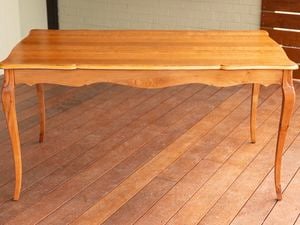 An image of a restored wooden table with a smooth finish is placed on a timber deck.