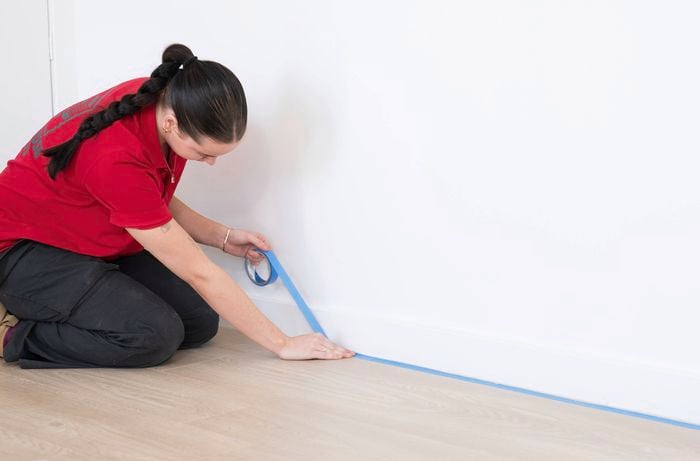 Prepare the room by applying blue painter's tape along the base