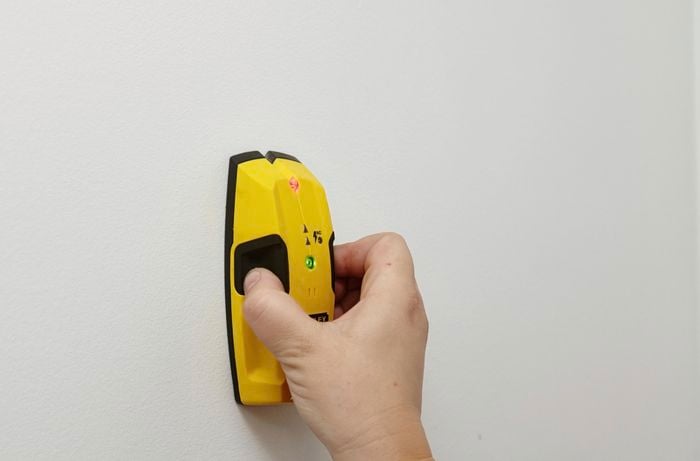 A stud finder used to find the stud in a white wall
