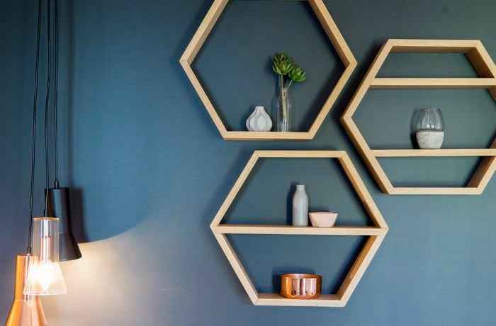 Hexagonal timber floating shelves on a blue wall