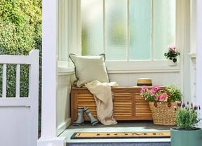 An entranceway featuring spring flowers and a timber daybed
