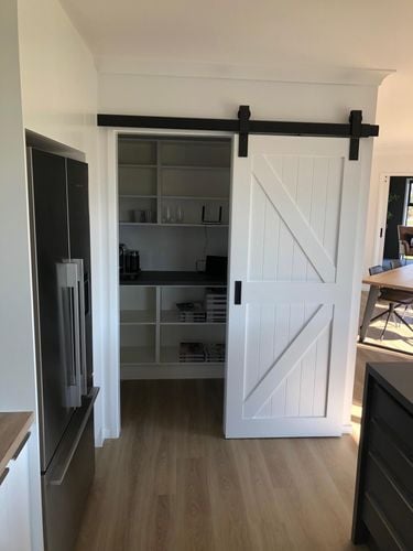 Kitchen cupboard with door on sliding rail