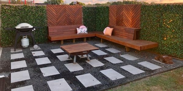 A fire pit and BBQ in a paved area with timber benches