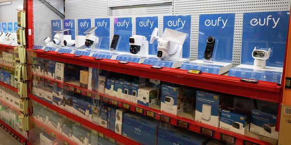 Eufy smart home security display in a Bunnings store, featuring security cameras, video doorbells and monitoring devices showcased on shelves with product packaging below.