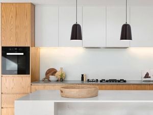 Modern kitchen with hanging black pendant lights.