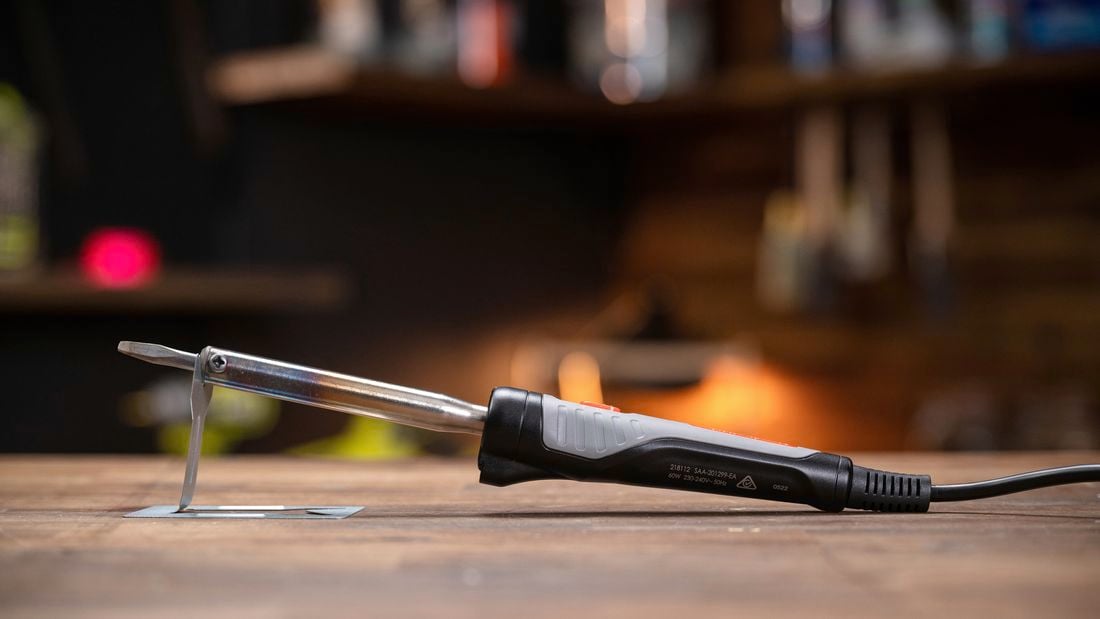 Side on image of a soldering iron placed on stand
