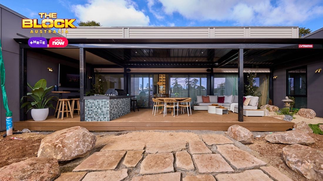 Back of a house with an outdoor setting, lounge and kitchen on decking.