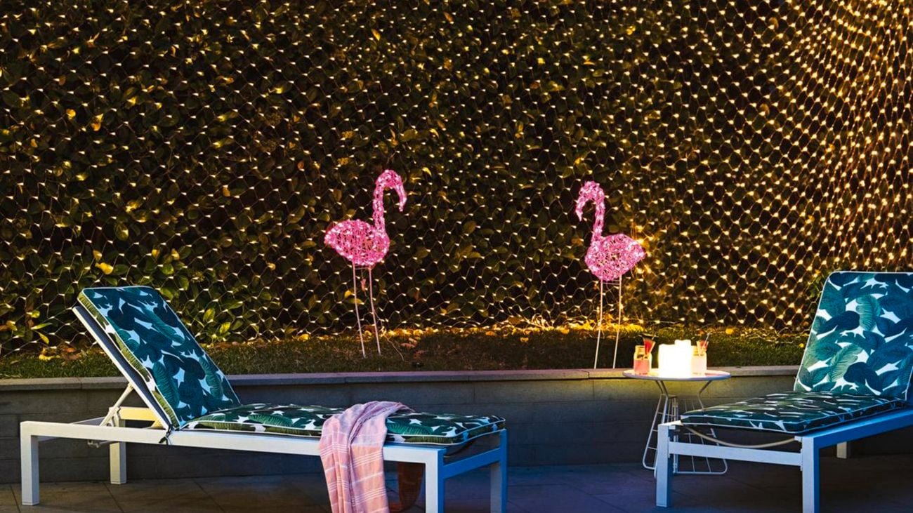 Wall of fairy lights, light flamingos and pool lounges.