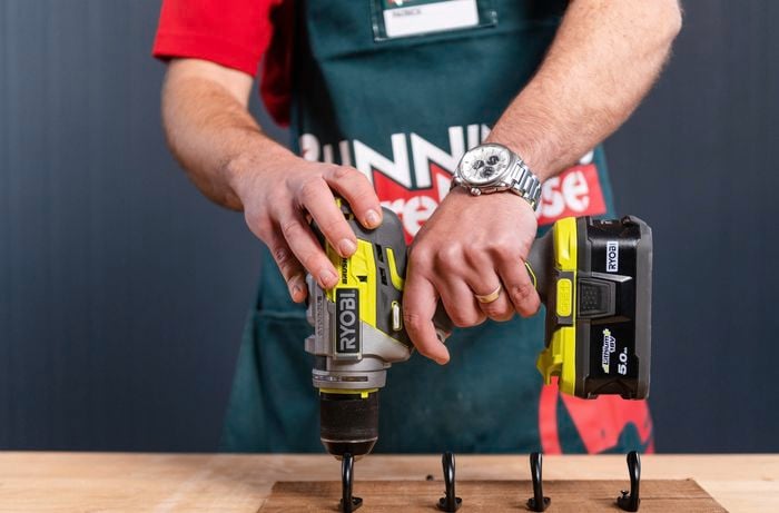 Using a power drill and drilling in hooks into timber
