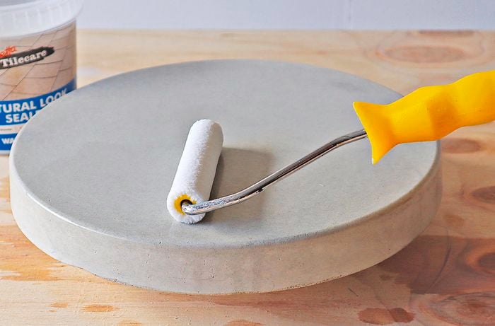 Person applying sealer with a roller