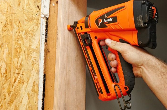 A door jamb being nailed in place with a nail gun