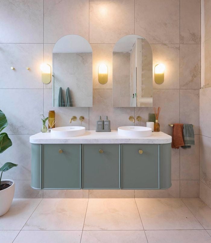 Blue and white bathroom with blue timber vanity, round basins and shower