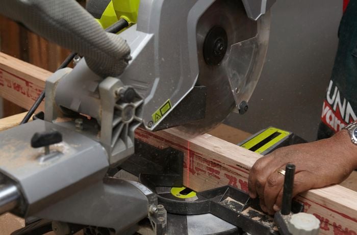 Person cutting timber using drop saw