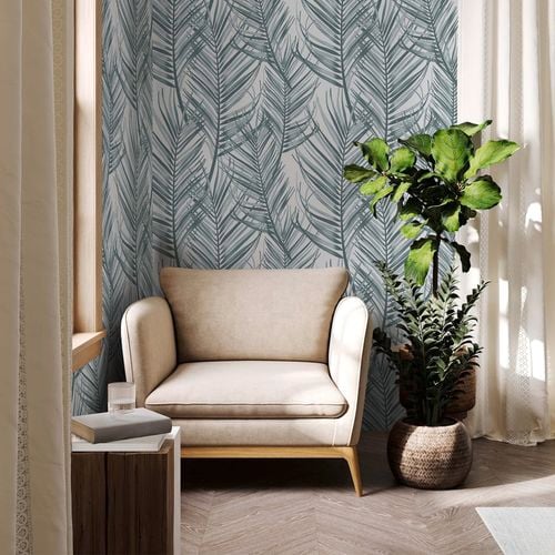 Occasional chair in front of a wallpaper with leaves.