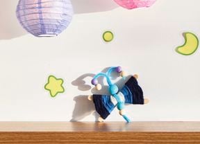 A D.I.Y. Bluey craft Flappy project sits on a timber shelf with a star, moon, planet and two Bluey lanterns about it.
