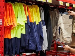 Customer in Bunnings aisle looking at workwear.